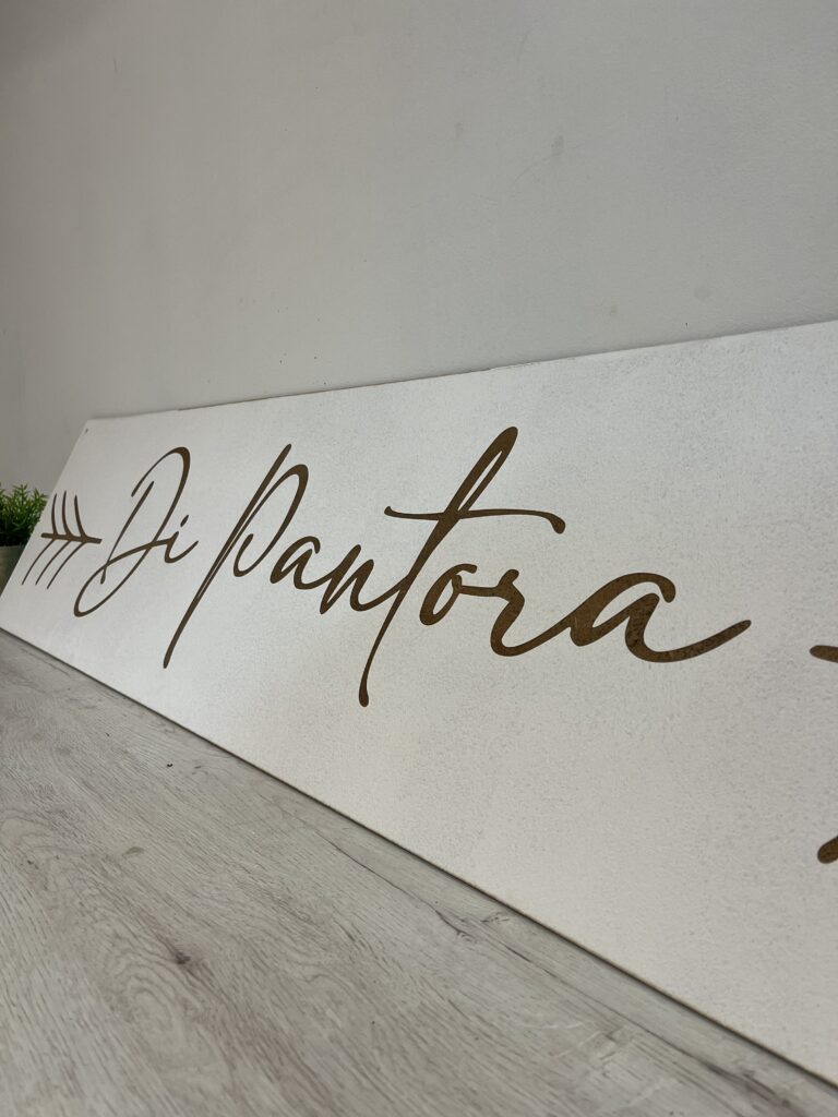 Detalle de una pieza de madera personalizada con letras decorativas